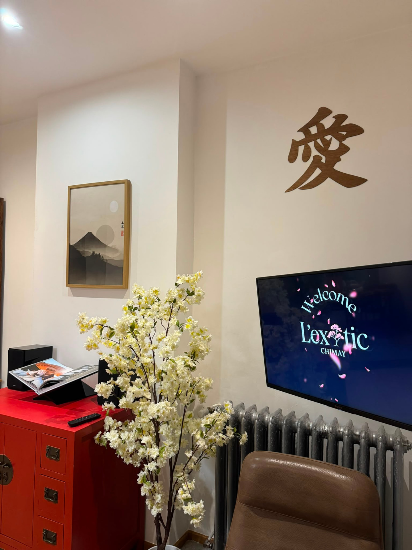 Accueil à l'écran du salon avec fleurs blanches et meuble rouge