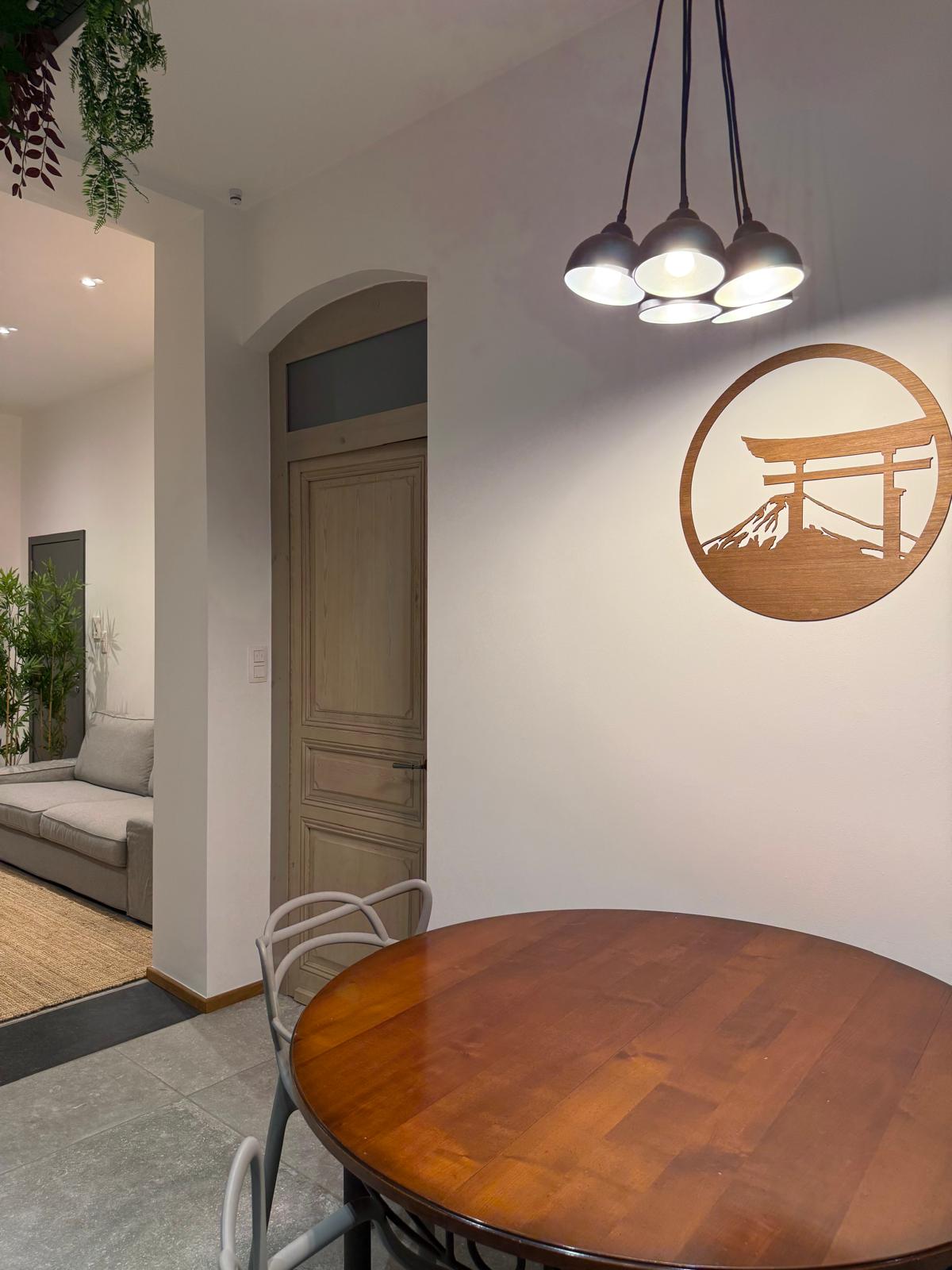 Coin repas avec table en bois, luminaires suspendus et décoration japonaise torii
